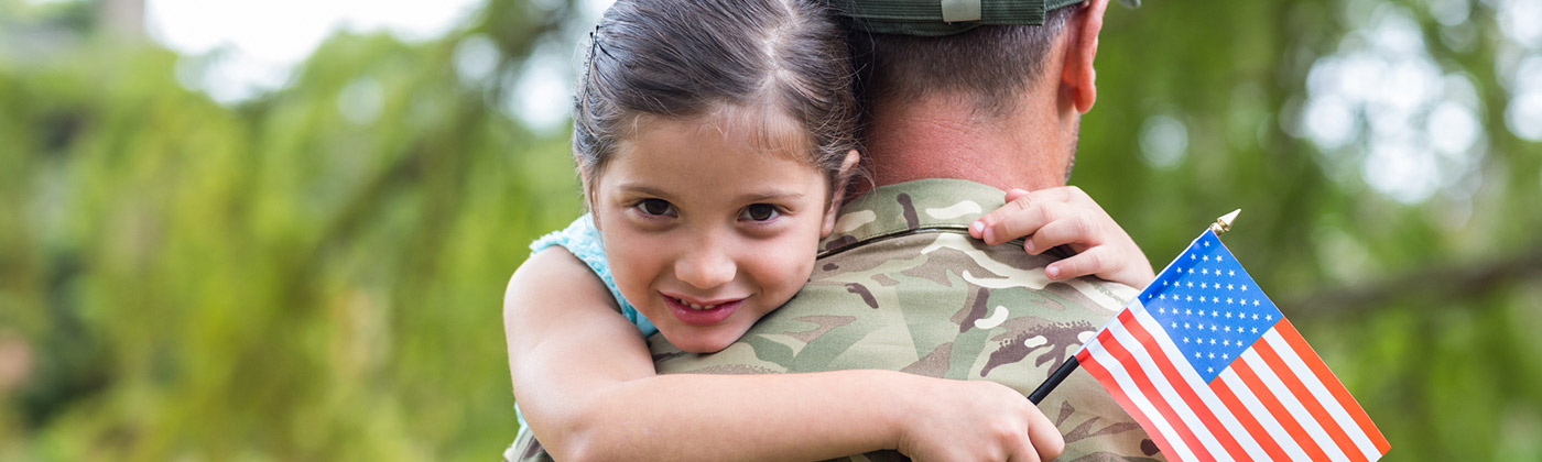 little girl hugging a military member